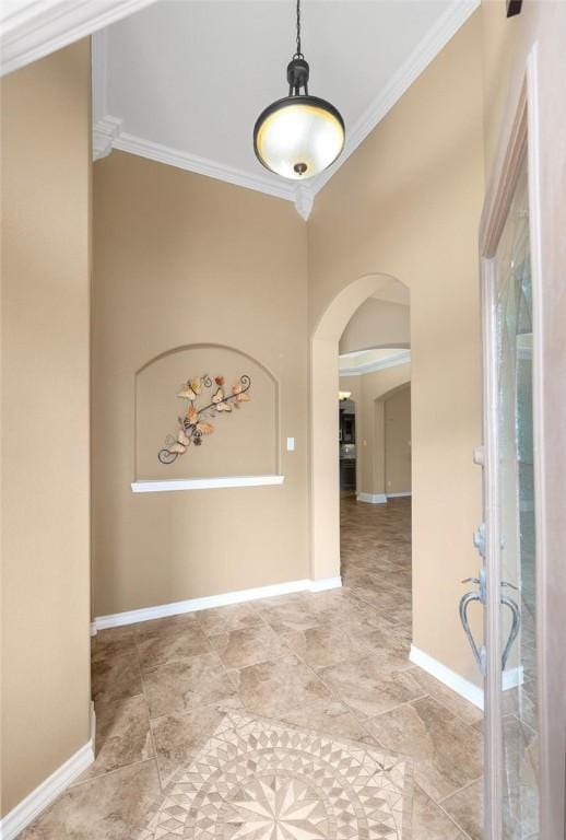 foyer with baseboards, arched walkways, and crown molding