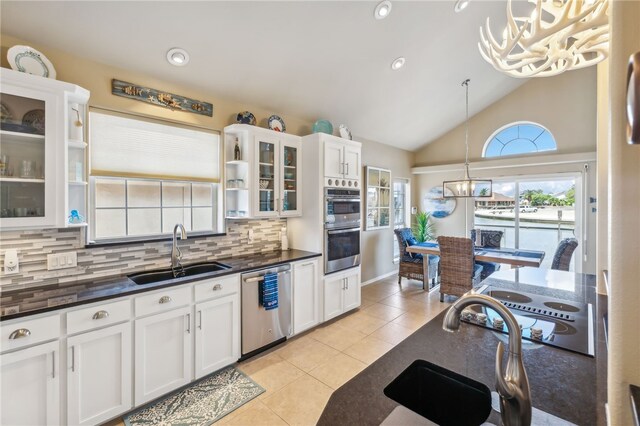 kitchen featuring tasteful backsplash, appliances with stainless steel finishes, pendant lighting, sink, and white cabinets