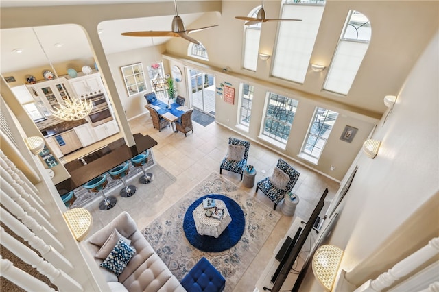 living room with ceiling fan, tile patterned flooring, and high vaulted ceiling