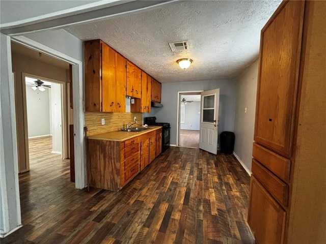 kitchen with tasteful backsplash, black electric range oven, sink, ceiling fan, and dark wood-type flooring