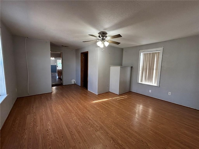 unfurnished room with ceiling fan, hardwood / wood-style floors, and a textured ceiling