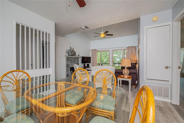 dining space featuring vaulted ceiling, a ceiling fan, visible vents, and light wood-style floors