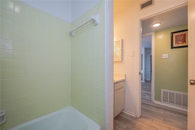 full bath with  shower combination, wood finished floors, vanity, and visible vents