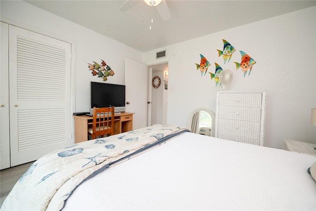 bedroom with ceiling fan, visible vents, a closet, and wood finished floors