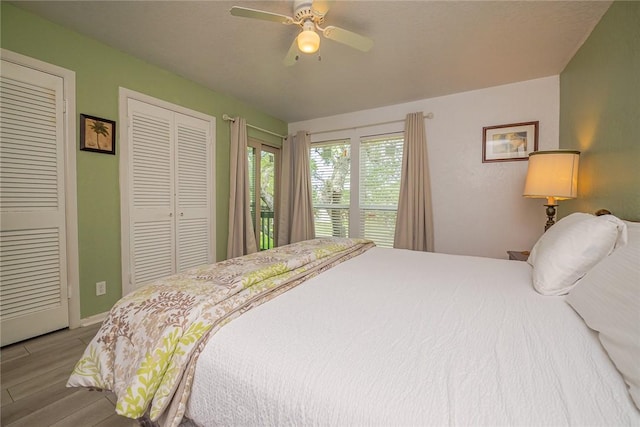 bedroom with multiple closets, a ceiling fan, and wood finished floors