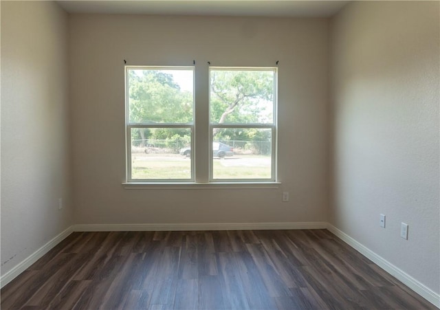 401 E Empresario St, Refugio, TX 78377 - empty room featuring dark wood-type flooring and baseboards