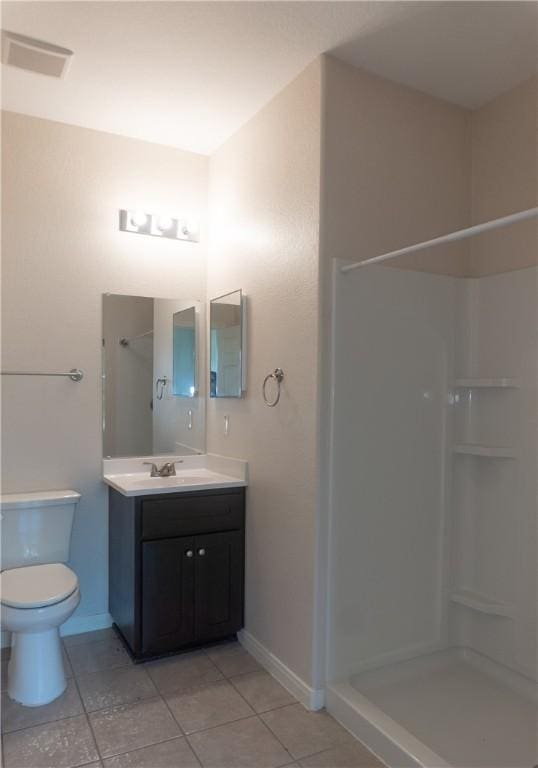 401 E Empresario St, Refugio, TX 78377 - full bathroom with tile patterned floors, a shower, vanity, and toilet