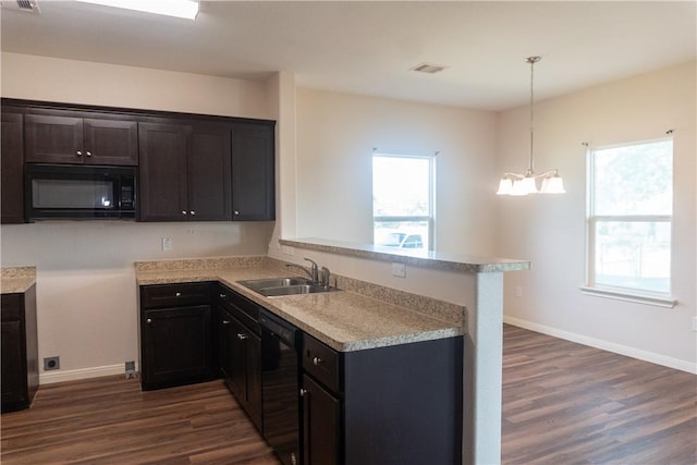 401 E Empresario St, Refugio, TX 78377 - kitchen featuring black appliances, a sink, dark wood-style floors, and a peninsula