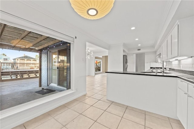 13731 Tajamar St, Corpus Christi, TX 78418 - kitchen featuring refrigerator, light tile patterned floors, white cabinetry, ornamental molding, and dark countertops