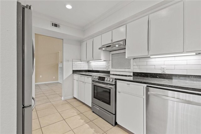 13731 Tajamar St, Corpus Christi, TX 78418 - kitchen with under cabinet range hood, appliances with stainless steel finishes, white cabinets, light tile patterned flooring, and ornamental molding