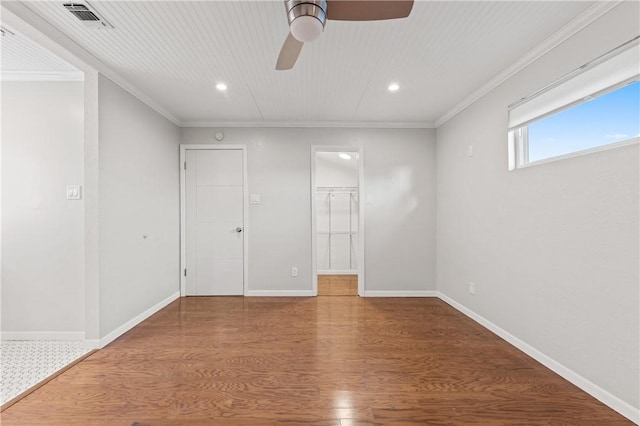 13731 Tajamar St, Corpus Christi, TX 78418 - unfurnished bedroom featuring wood finished floors, crown molding, recessed lighting, baseboards, and a spacious closet