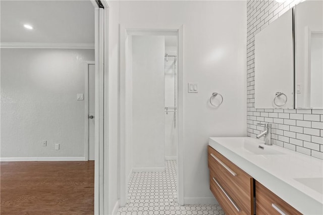 13731 Tajamar St, Corpus Christi, TX 78418 - bathroom featuring double vanity, backsplash, crown molding, and baseboards