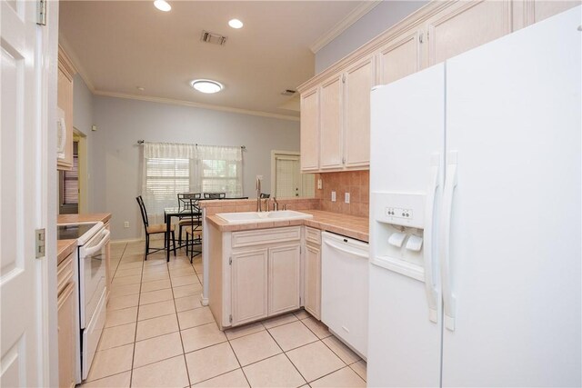 3829 Brockhampton Ct, Corpus Christi, TX 78414 - kitchen with white appliances, light tile patterned floors, a peninsula, crown molding, and backsplash