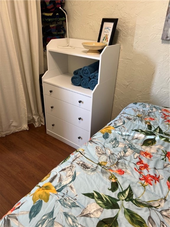 bedroom with dark wood-type flooring