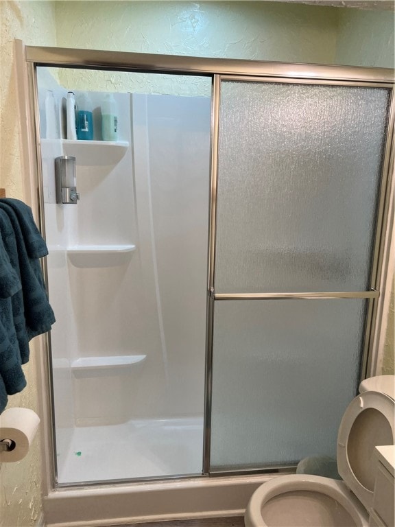 bathroom featuring walk in shower, vanity, and toilet