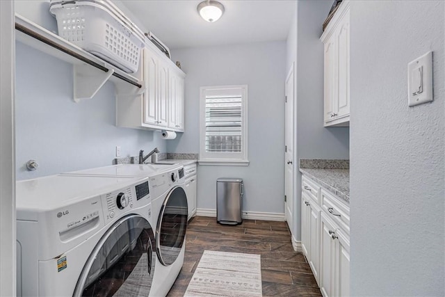 laundry area featuring washing machine and clothes dryer, sink, and cabinets