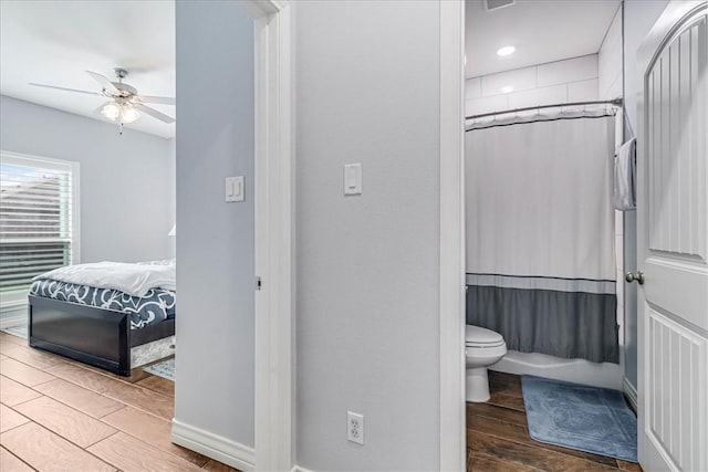 bathroom featuring shower / bath combination with curtain, toilet, and ceiling fan