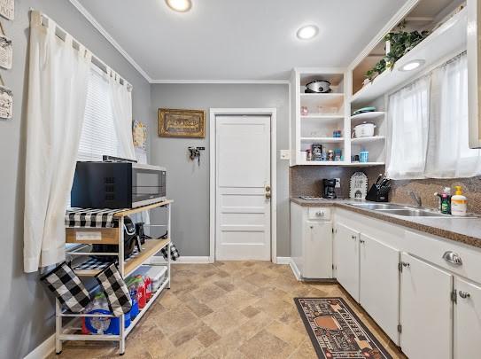 1058 Vaky St, Corpus Christi, TX 78404 - kitchen featuring white cabinets, stainless steel microwave, ornamental molding, open shelves, and light countertops