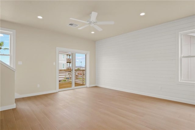 empty room featuring a ceiling fan, baseboards, visible vents, light wood-style flooring, and recessed lighting