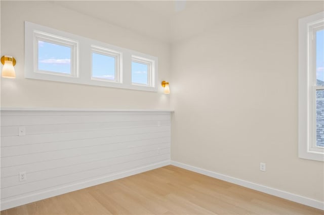 unfurnished room with baseboards and light wood-style flooring