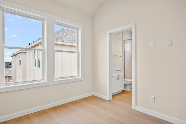 spare room featuring light wood-type flooring and baseboards