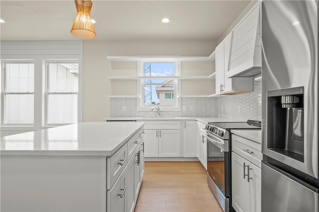 kitchen featuring open shelves, stainless steel appliances, light wood-style floors, and decorative backsplash