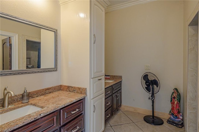 bathroom with tile patterned floors, baseboards, ornamental molding, and vanity