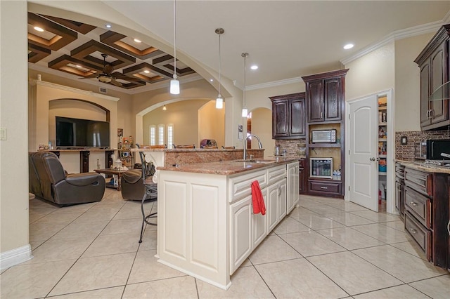 kitchen featuring a kitchen bar, a sink, coffered ceiling, open floor plan, and light tile patterned floors