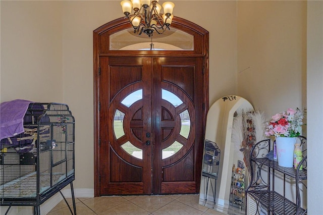 entrance foyer with light tile patterned flooring, baseboards, and a chandelier