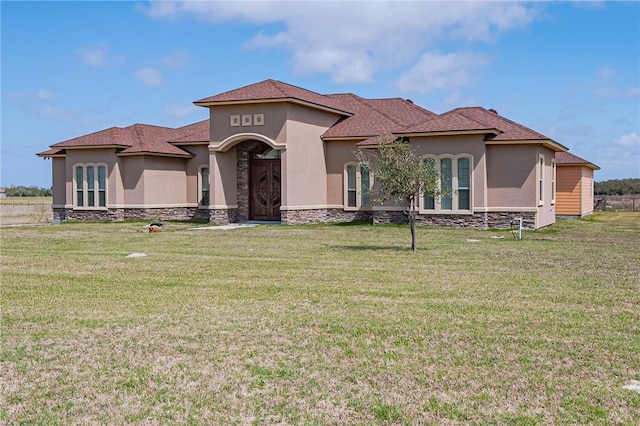 mediterranean / spanish home with stucco siding and a front yard