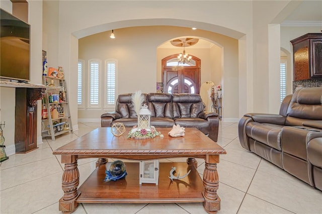 living area featuring an inviting chandelier, light tile patterned floors, baseboards, and arched walkways