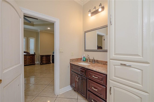 bathroom with vanity, crown molding, baseboards, and tile patterned floors