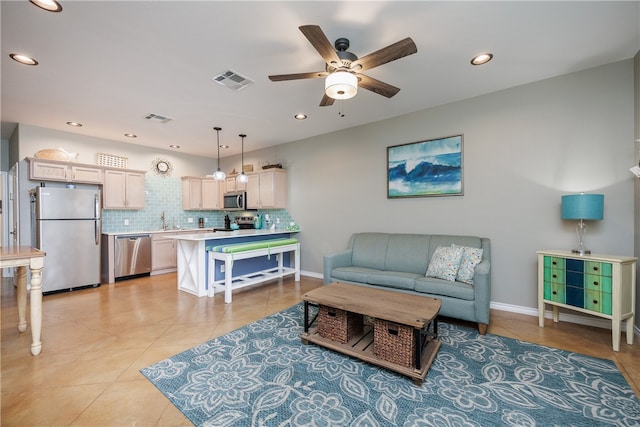 tiled living room featuring ceiling fan and sink