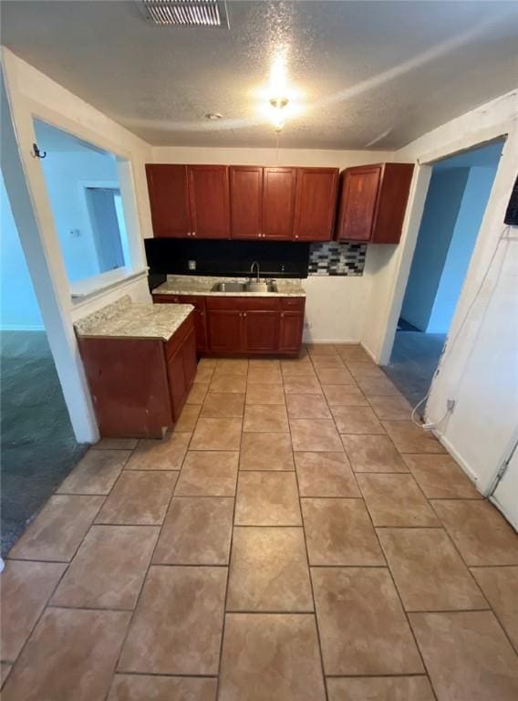 kitchen featuring light tile patterned flooring, a textured ceiling, and sink