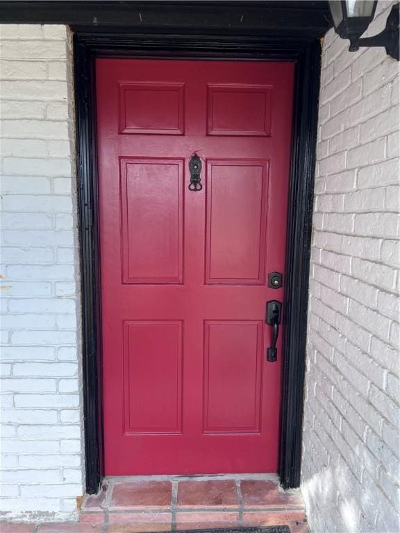 doorway to property featuring brick siding