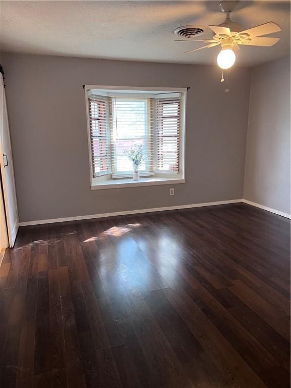 empty room with dark wood-style flooring and baseboards