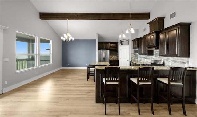 kitchen featuring a chandelier, beam ceiling, light wood-type flooring, and pendant lighting