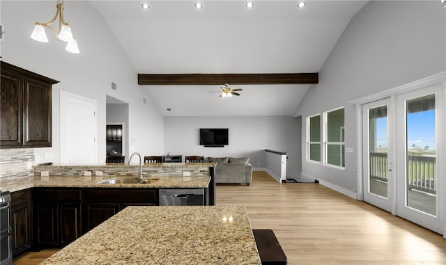 kitchen featuring light wood-type flooring, ceiling fan with notable chandelier, sink, pendant lighting, and dishwasher