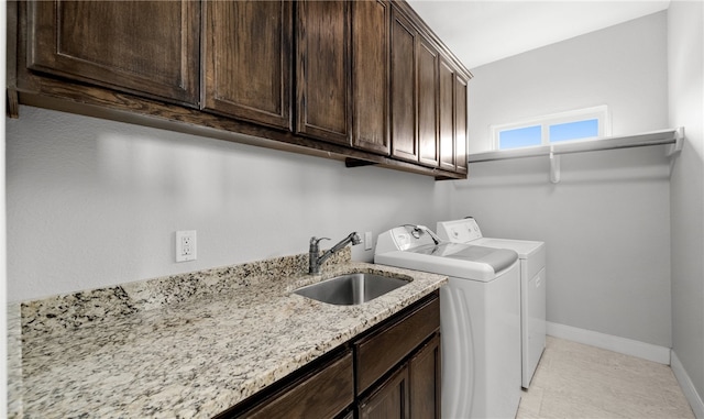 laundry room featuring cabinets, washer and clothes dryer, and sink