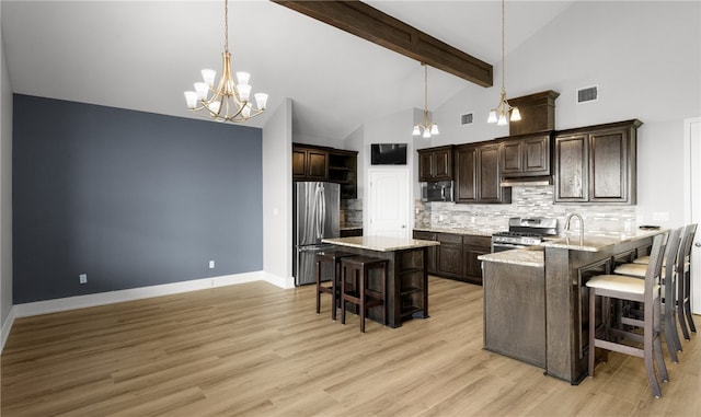 kitchen featuring a kitchen bar, kitchen peninsula, stainless steel appliances, and light hardwood / wood-style flooring