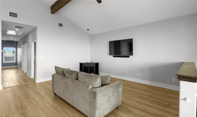 living room featuring beamed ceiling, light wood-type flooring, high vaulted ceiling, and ceiling fan