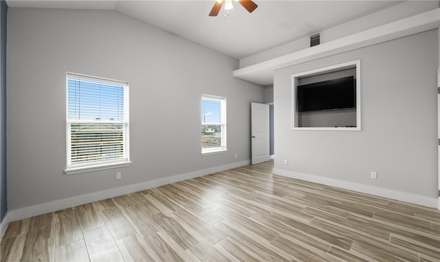 empty room with light wood-type flooring, vaulted ceiling, and ceiling fan