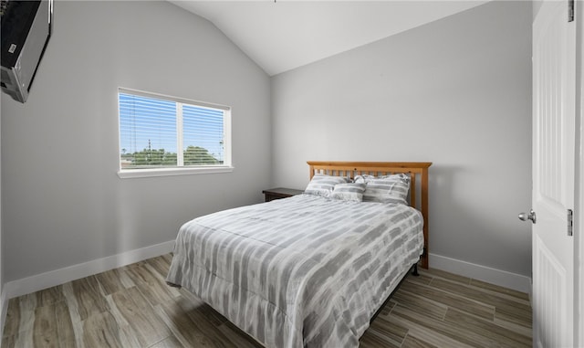 bedroom with wood-type flooring and vaulted ceiling