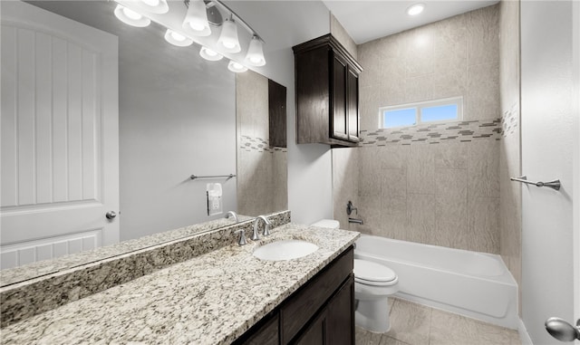 full bathroom featuring tile patterned flooring, toilet, vanity, and tiled shower / bath