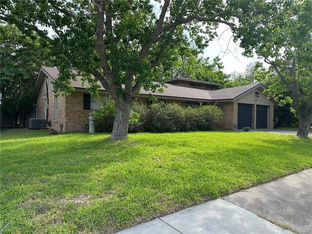 4117 Cork Dr, Corpus Christi, TX 78413 - view of front facade with brick siding, an attached garage, a front lawn, and concrete driveway