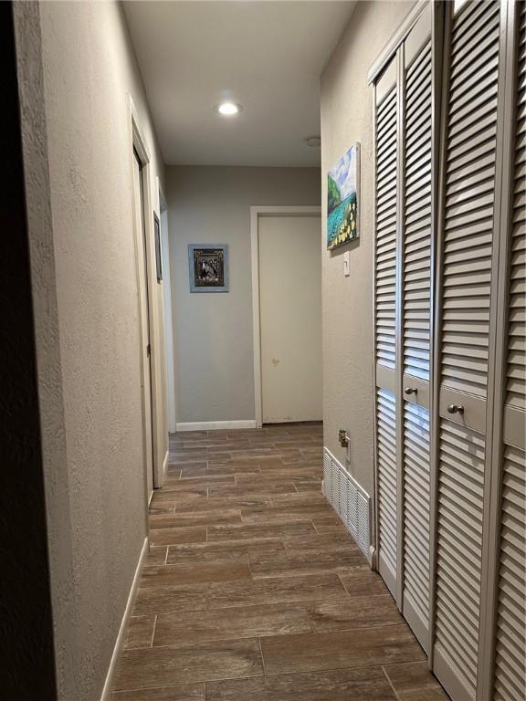 4117 Cork Dr, Corpus Christi, TX 78413 - corridor featuring wood finished floors, a textured wall, and recessed lighting