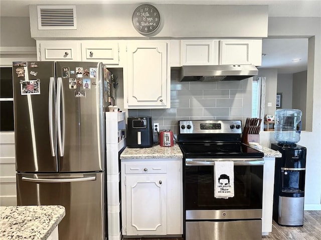 4117 Cork Dr, Corpus Christi, TX 78413 - kitchen with stainless steel appliances, under cabinet range hood, white cabinets, tasteful backsplash, and wood finished floors