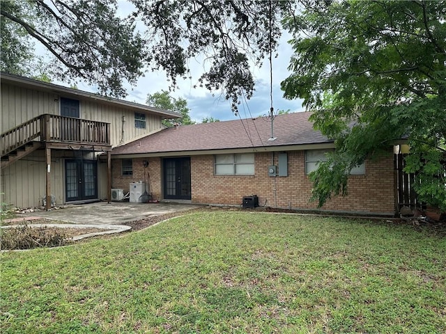 4117 Cork Dr, Corpus Christi, TX 78413 - view of front of home with french doors, brick siding, a front lawn, and a patio