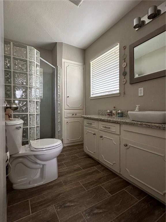 4117 Cork Dr, Corpus Christi, TX 78413 - bathroom with wood finish floors, vanity, a shower stall, and a textured ceiling