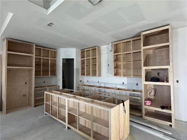 kitchen featuring open shelves, unfinished concrete floors, and a center island